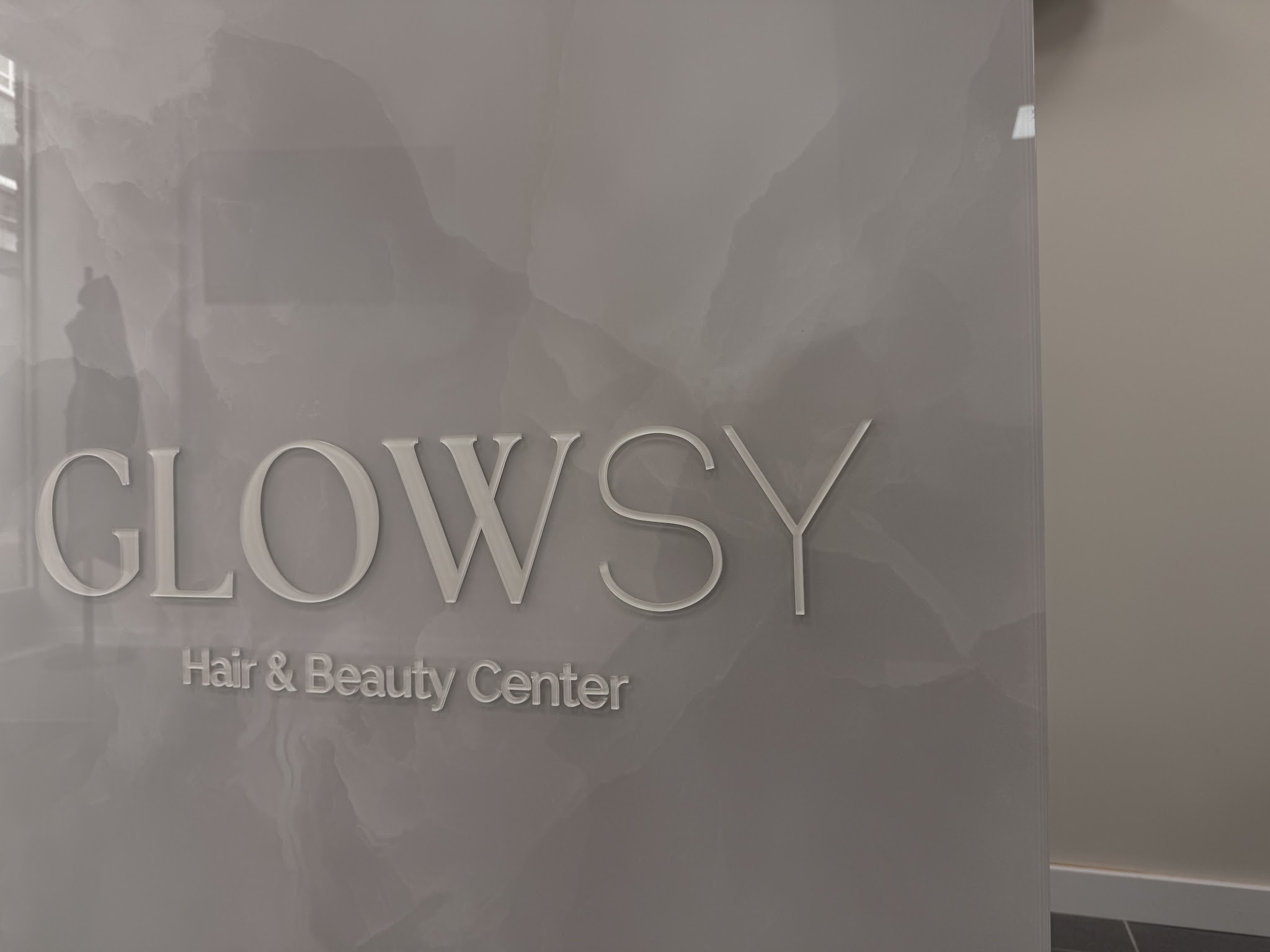 Het Glowsy woordmerk op de wand in de salon
