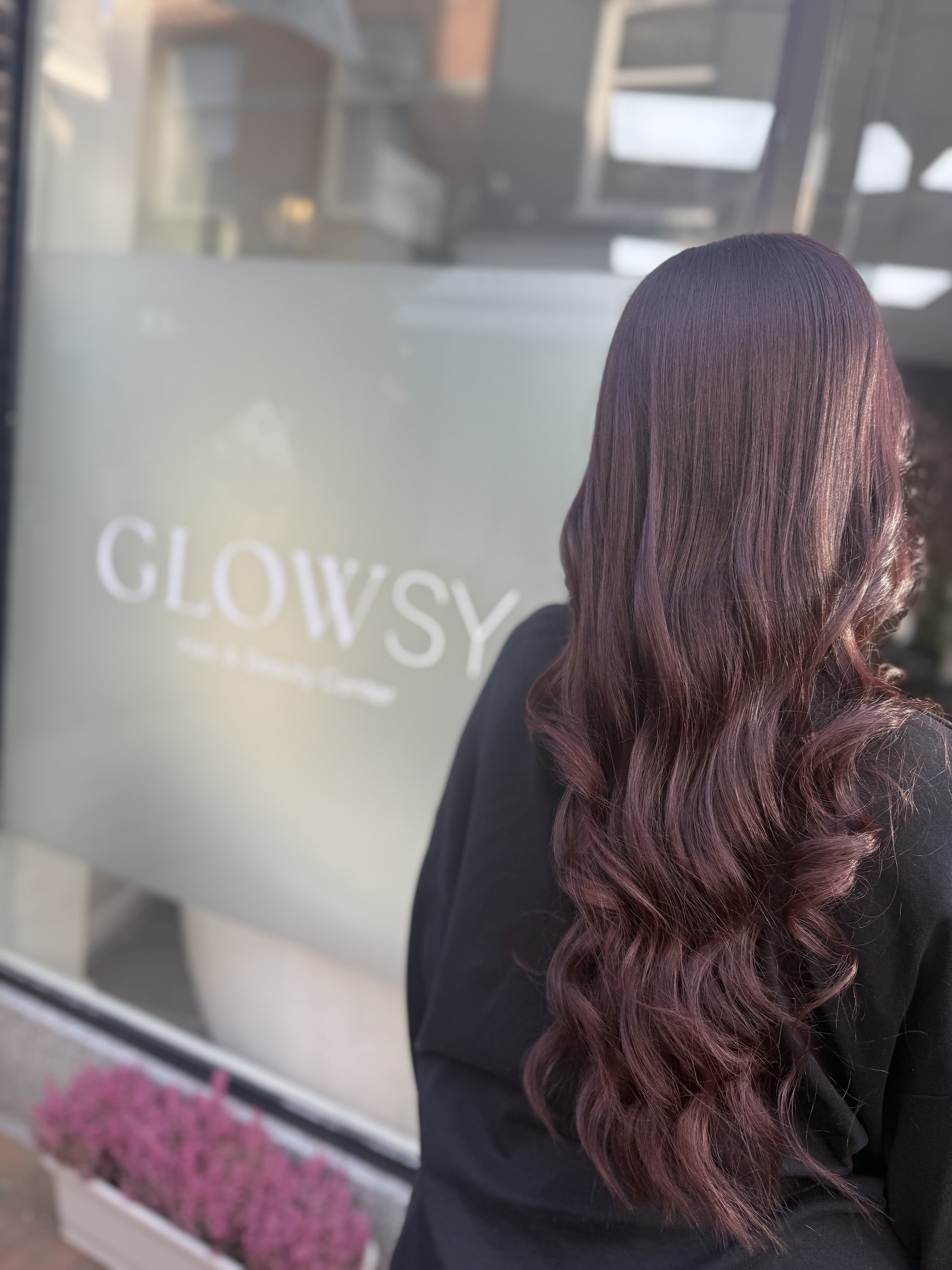 Lang donker haar met glanzende krullen, een afgewerkt kapsel bij Glowsy Center